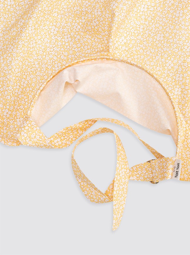 Bavoir jaune à fleurs blanches