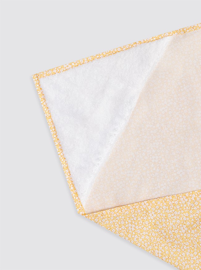 Bavoir jaune à fleurs blanches